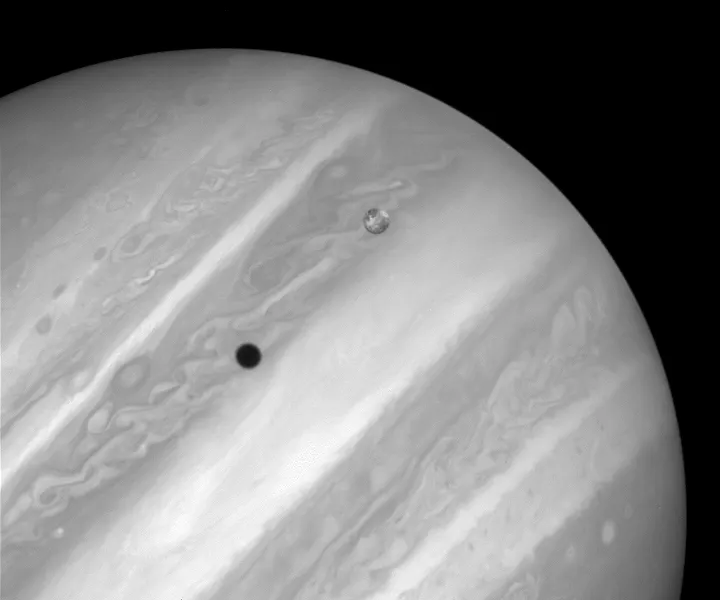 Io casting a shadow on Jupiter. Although Io is not the largest moon of Jupiter, it casts the largest shadow due to its closer orbit around the planet. Image by the Hubble Space Telescope.