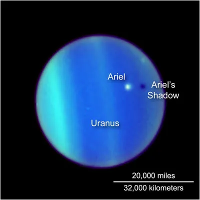 Ariel, the fourth largest moon of Uranus, casting a shadow on the planet. Image by the Hubble Space Telescope.